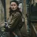 Nancy Wake, WWII Allied spy and resistance fighter in 1940s setting, white female with dark wavy hair in victory rolls, wearing a French resistance trench coats, standing beside a vintage bicycle