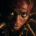Close up of Anansi the Spider from West African folklore, a human form but with eight long spider legs, faint African symbols
