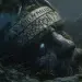Severed head of Mimir resting beside the Well of Wisdom, preserved with runes carved into stone, one glowing eye, roots of Yggdrasil overhead